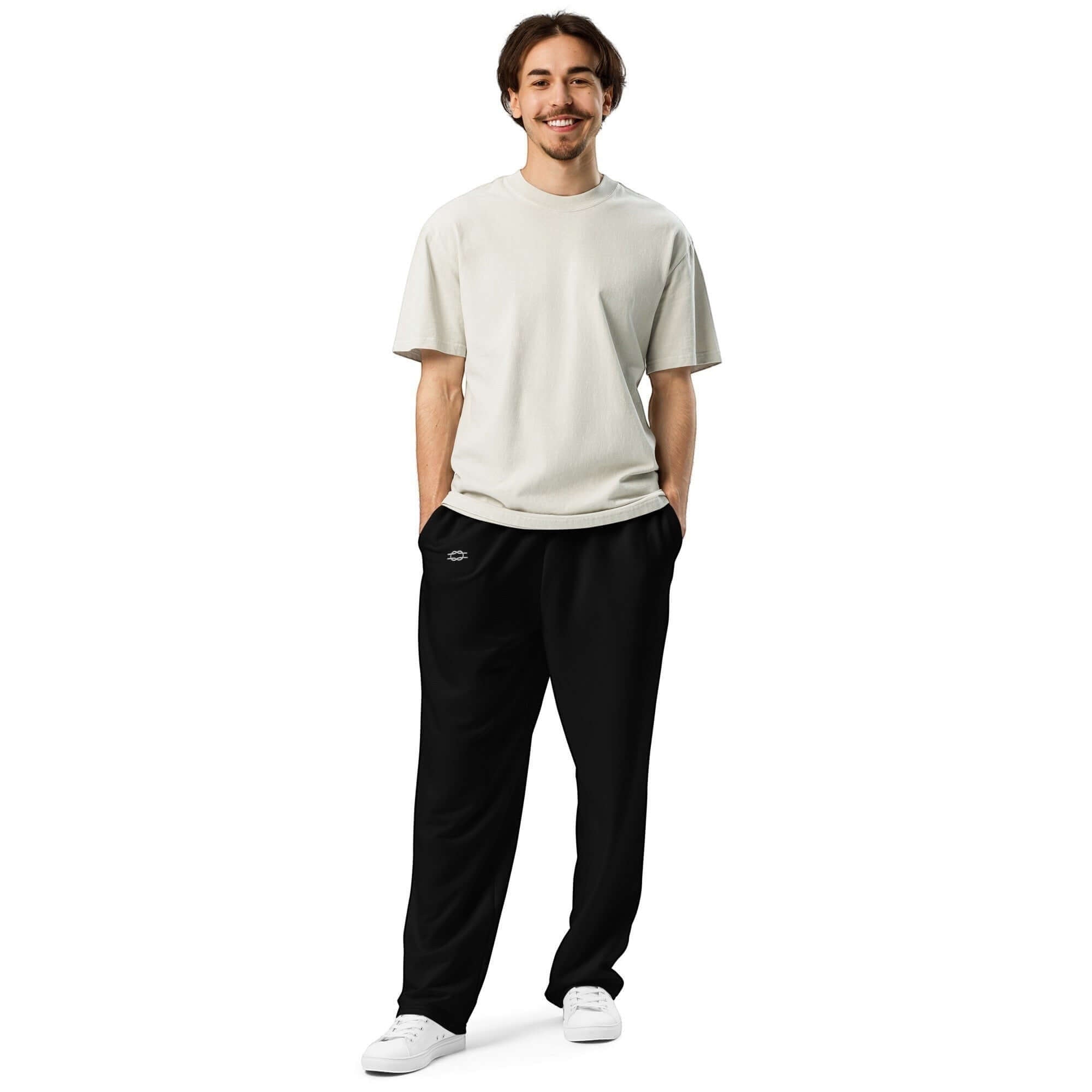 Model wearing Urban Halo black wide-leg joggers and a beige t-shirt, standing against a white background.